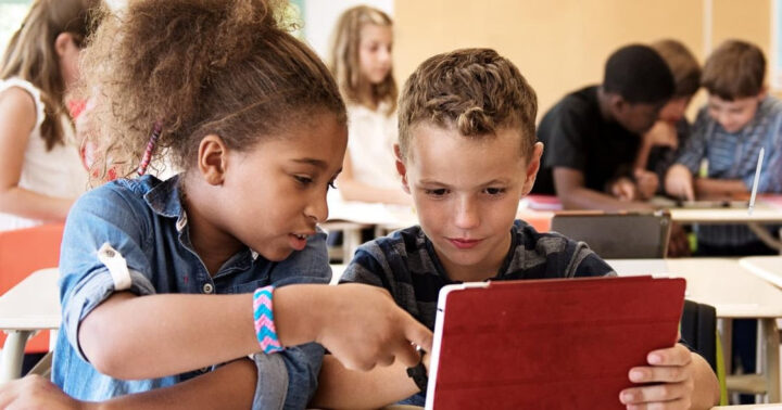 Enfants lisant sur tablette.